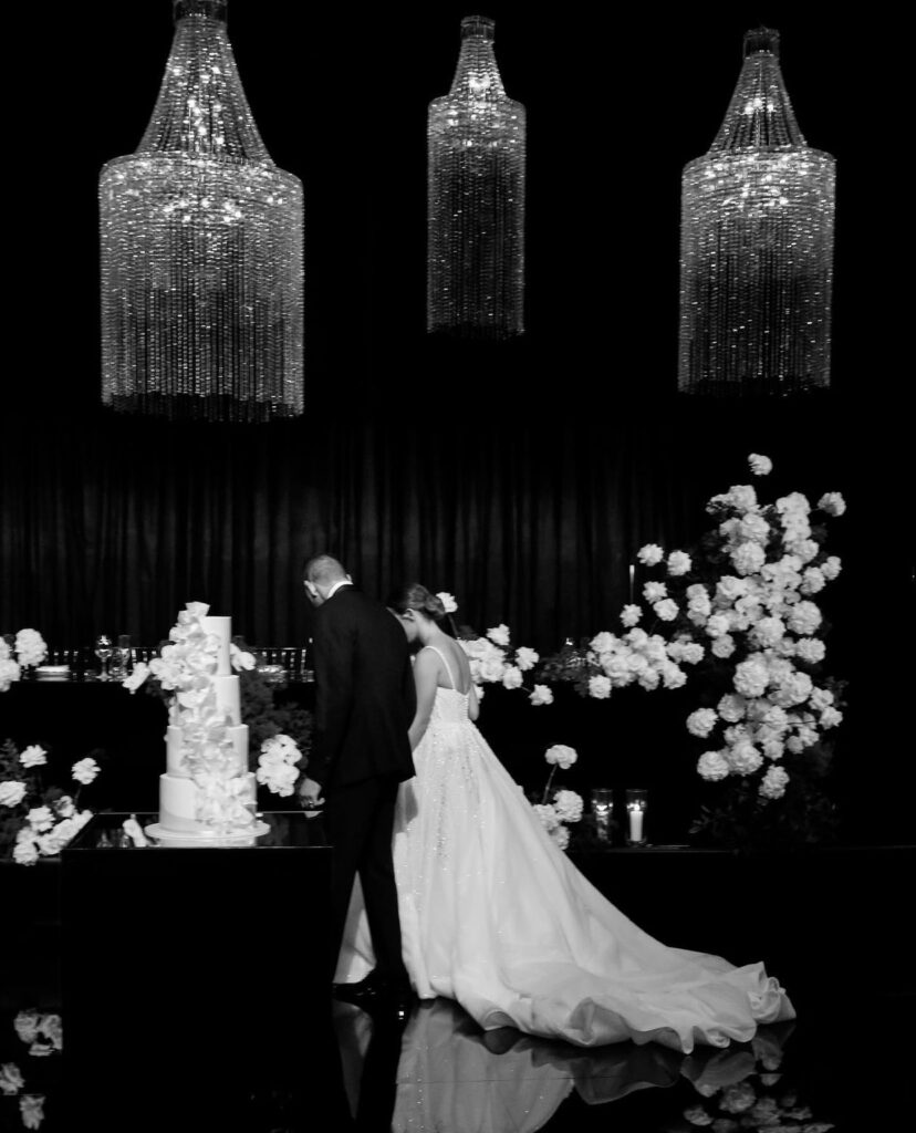 wedding cake photo with the bride and groom and white flowers 